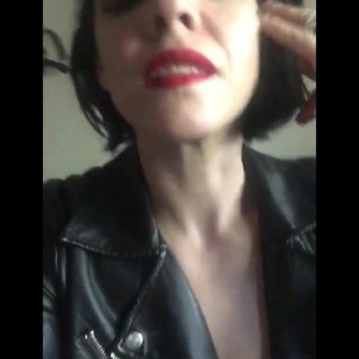 Hot goth chick smokes cigarette close up in leather jacket and red lipstick